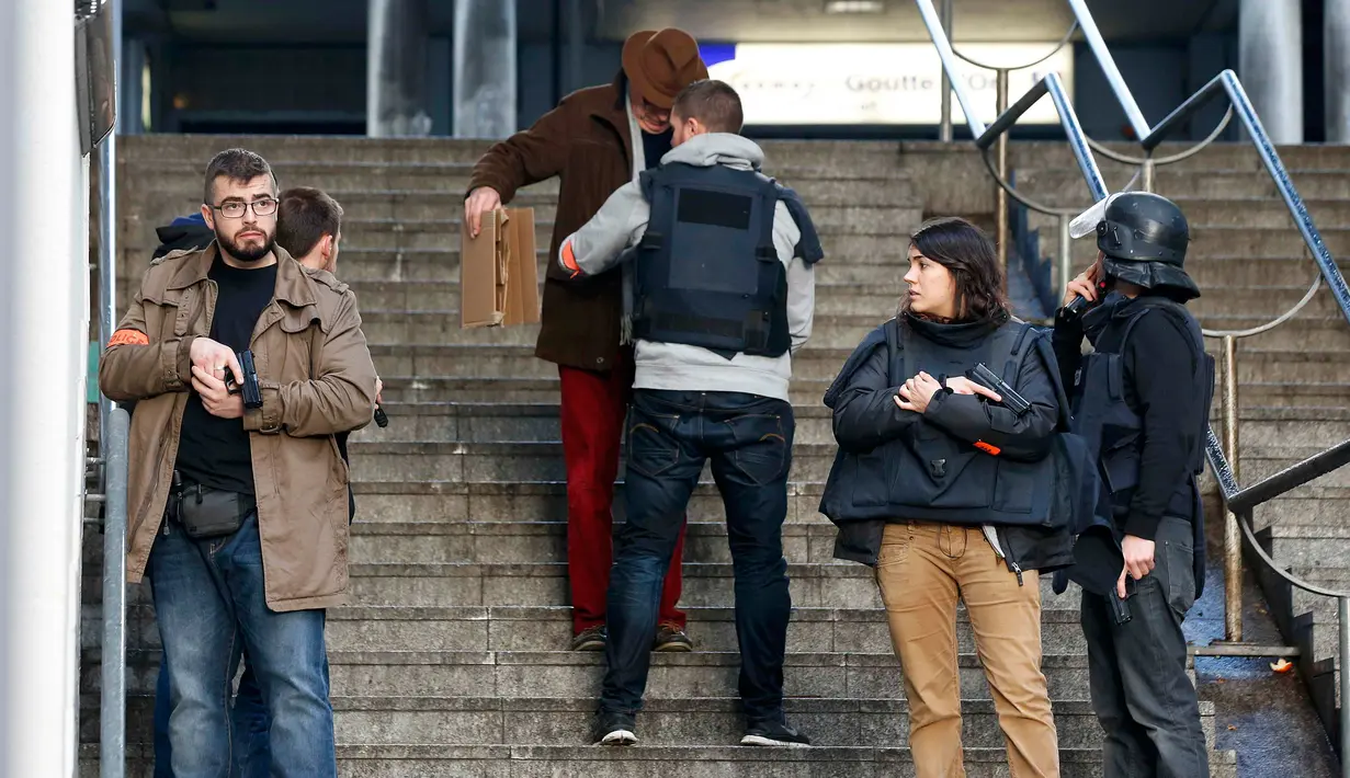 Petugas memeriksa pejalan kaki usai seorang pria ditembak mati di sebuah kantor polisi di Paris, Prancis, Kamis (7/1/2016). Pria itu ditembak mati karena memaksa masuk ke kantor polisi dengan mengenakan rompi peledak. (REUTERS/Philippe Wojazer)