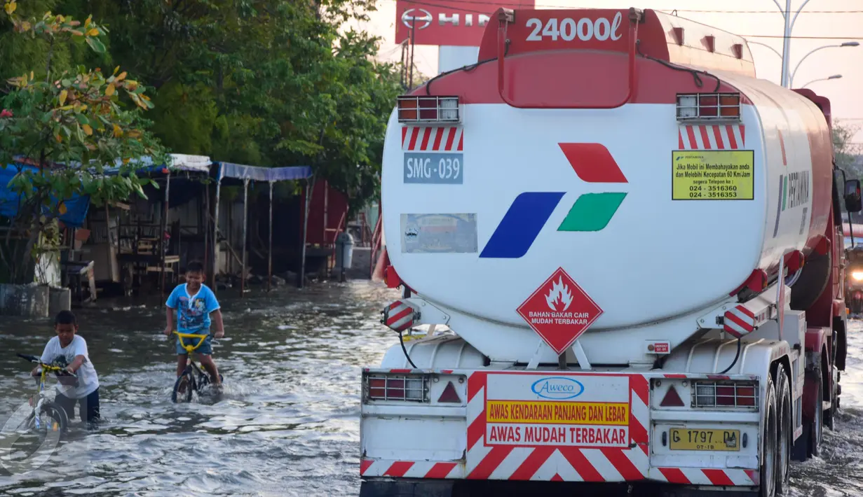 Banjir rob atau air laut pasang menggenangi ruas jalur pantura Semarang-Demak, Jawa Tengah, Minggu (12 /06/2016). Meski banjir yang cukup tinggi hanya kendaraan besar truk atau bus yang bisa melintas. (Gholib)