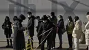 Petugas memasang garis barikade ketika orang-orang mengantre untuk mendapatkan tes COVID-19 di fasilitas pengujian virus corona seluler di Beijing (16/1/2022). Beijing telah melaporkan infeksi omicron lokal pertamanya, beberapa minggu sebelum Olimpiade Musim Dingin akan dimulai. (AP Photo/Andy Wong)