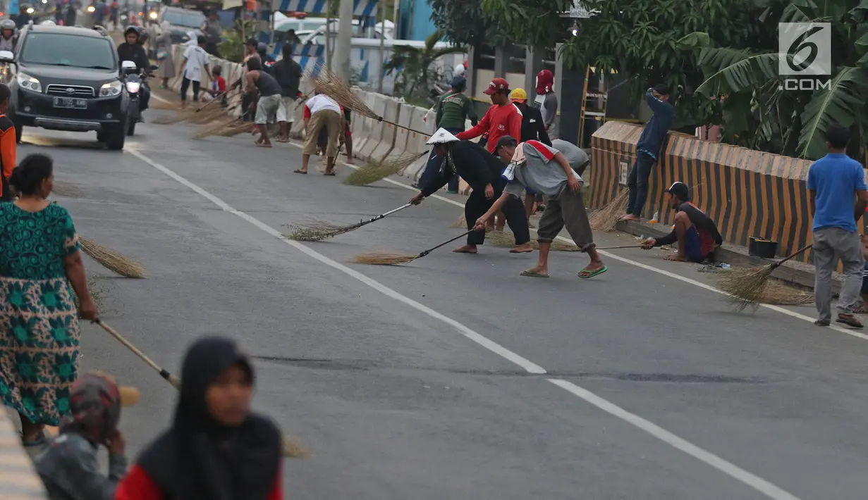 Warga berebut uang yang dilemparkan pengguna jalan menggunakan sapu di Jembatan Sewo, Indramayu, Jawa Barat, Senin (3/6/2019). Kehadiran pencari sedekah tersebut biasanya kian bertambah banyak saat menjelang arus mudik Lebaran. (Liputan6.com/Herman Zakharia)