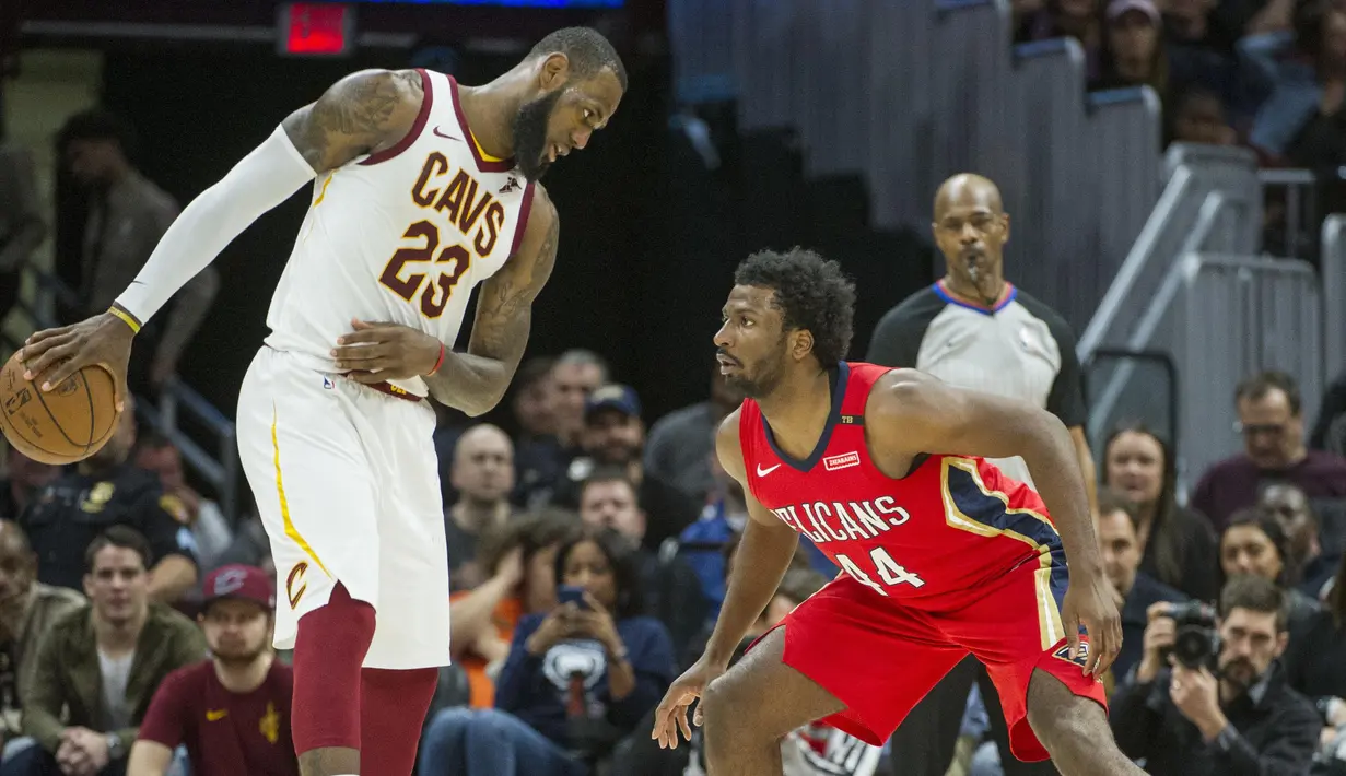 Pebasket New Orleans Pelicans, Solomon Hill, menjaga pebasket Cleveland Cavaliers, LeBron James, pada laga NBA di Quicken Loans Arena, Sabtu (31/3/2018). Cavaliers menang 107-102 atas Pelicans. (AP/Phil Long)