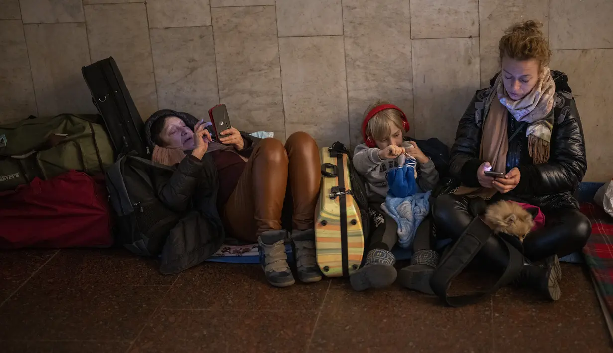Orang-orang beristirahat di kereta bawah tanah Kiev, menggunakannya sebagai tempat perlindungan bom di ibu kota Ukraina, Kamis, 24 Februari 2022. Warga di Kiev tampak berlindung di stasiun bawah tanah kota dan tempat-tempat aman lainnya untuk menghindari invasi Rusia. (AP Photo/Emilio Morenatti)