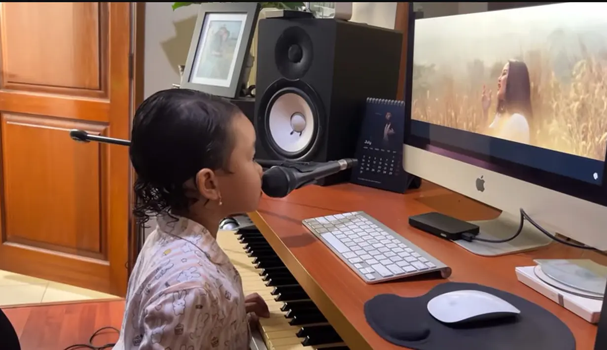 Ayah dan ibunya musisi menurun ke sang anak. Momen Gewa latihan nyanyi. Matanya tertuju ke layar monitor, sedangkan jari-jarinya memencet-mencet piano. Menurut Mutia Ayu, setelah mandi Gewa langsung menunju studio di rumahnya dan bernyanyi. [Youtube/Mutia Ayu]