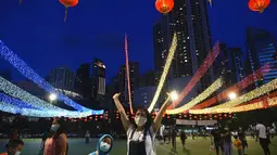 Orang-orang foto di depan dekorasi selama Festival Pertengahan Musim Gugur di taman Victoria di Hong Kong, Selasa (21/9/2021).  Festival ini didatangi keluarga dan teman Tionghoa untuk berkumpul makan kue bulan China dan pomelo bersama-sama. (AP Photo/Vincent Yu)