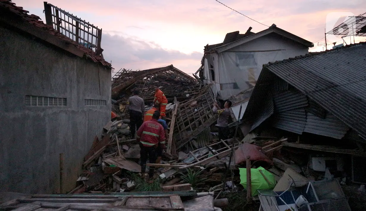 Petugas memeriksa rumah yang rusak akibat gempa bumi di Ciheranhg Jaya, Pacet, Cianjur, Jawa Barat, Senin (21/11/2022). Longsor akibat gempa membawa sebuah angkot yang diduga berisi penumpang dan truk ke dalam jurang, evakuasi pun akan dilanjutkan esok hari. (merdeka.com/Arie Basuki)
