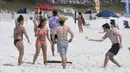 Para pengunjung pantai asyik bermain bola di Destin, Florida, Amerika Serikat, Rabu (18/3/2020). Virus corona COVID-19 sudah menyebar ke seluruh wilayah Amerika Serikat dengan jumlah kasus sebanyak 5.359 dan menewaskan 100 orang. (Devon Ravine/Northwest Florida Daily News via AP)