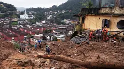 Petugas penyelamat mencari korban selamat setelah tanah longsor di Petropolis, Brasil, 16 Februari 2022. Banjir skala besar menghancurkan ratusan properti dan merenggut sebanyak 34 nyawa di daerah tersebut. (CARL DE SOUZA/AFP)