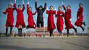 Sejumlah wanita berpose dengan latar belakang Istana Kuno Dinasti Ming dan Qing saat menyambut peserta Kongres Rakyat Nasional di Beijing, China, Senin (4/3). Kongres ini digelar setiap tahun. (AP Photo/Mark Schiefelbein)