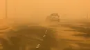 Kendaraan melintas di sepanjang jalan raya yang diselimuti debu tebal selama terjangan badai pasir di Kuwait City, Kuwait, pada 17 Juni 2021. Terjangan badai pasir ini membuat jarak pandang atau visibilitas di beberapa daerah turun hingga kurang dari 100 meter. (AFP/YasserAl-Zayyat)