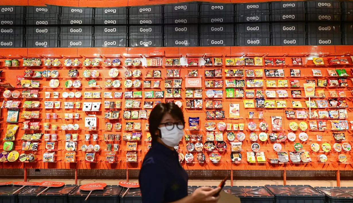 Seorang wanita berjalan melewati mie instan yang dipajang di toko Good Noodle dengan lebih dari 70 jenis mie instan untuk dijual dari seluruh Asia, di Bangkok (25/8/2022). Thailand akan menaikkan harga mie instan Thailand, kata departemen perdagangan 24 Agustus menandai kenaikan harga pertama pada kebutuhan pokok harian dalam 14 tahun. (AFP/Vatsyayana)