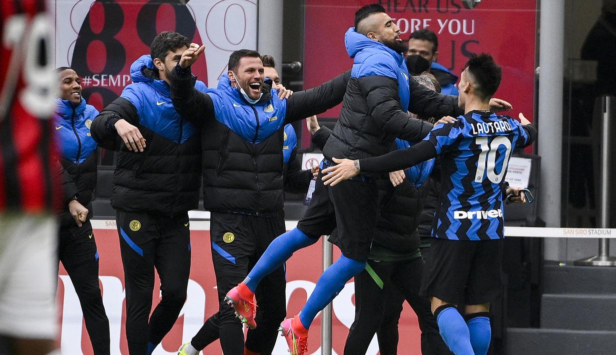 Striker Inter Milan, Lautaro Martinez (kanan) bersama para pemain cadangan merayakan gol kedua ke gawang AC Milan dalam laga lanjutan Liga Italia 2020/21 pekan ke-23 di San Siro Stadium, Minggu (21/2/2021). Inter Milan menang 3-0 atas AC Milan. (LaPresse via AP/Marco Alpozzi)