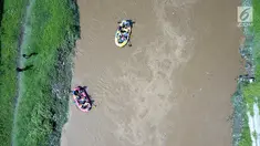 Peserta dengan perahu karet  menyusuri Sungai Ciliwung sambil membersihkan sampah pada acara Bersih-Bersih Sungai Ciliwung, Jakarta, Minggu (08/4). Kegiatan tersebut merupakan rangkaian HUT Kementerian BUMN. (Liputan6.com/Fery Pradolo)