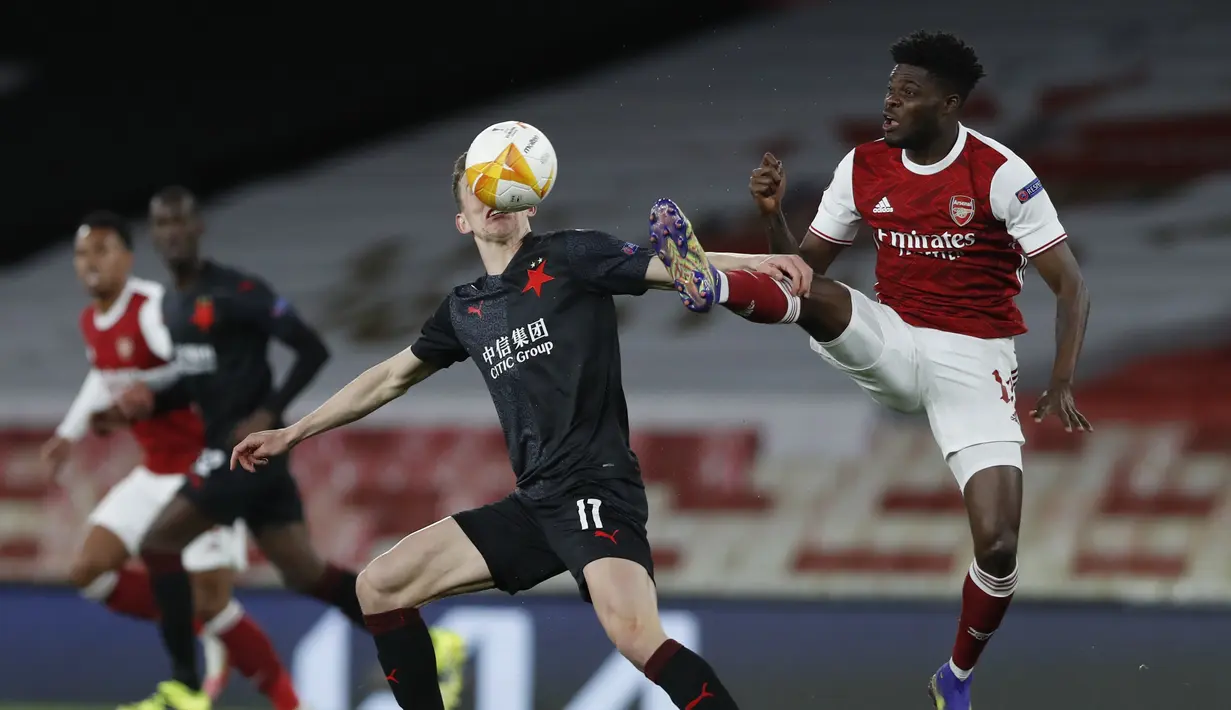Gelandang Arsenal, Thomas Partey berebut bola dengan pemain Slavia Praha,  Lukas Provod pada pertandingan leg pertama perempat final Liga Europa di Stadion Emirates di London, Jumat (9/4/2021). Arsenal bermain imbang atas Slavia Praha 1-1.  (AP Photo/Alastair Grant)