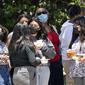 Orang-orang mengenakan masker saat menunggu di halte bus di sepanjang Hill Street, Los Angeles pada Rabu (13/7/2022). Los Angeles County mungkin memberlakukan mandat masker pada 29 Juli 2022 jika jumlah COVID-19 terus meningkat. (AP Photo/Marcio Jose Sanchez)