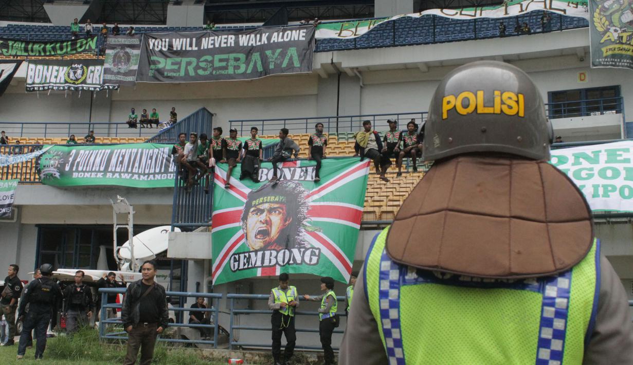 Polisi berjaga dekat Bonek yang memberi dukungan kepada timnya saat melawan PSIS Semarang pada laga perdana babak 8 besar Grup Y Liga 2 Indonesia di Stadion GBLA, Bandung, (15/11/2017). Persebaya menang atas PSIS Semang 1-0. (Bola.com/Ronald Seger)