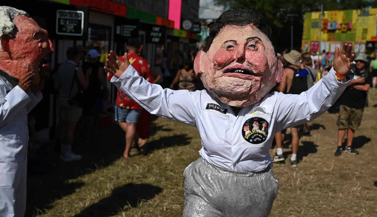 Seorang penampil mengenakan topeng yang menggambarkan Elon Musk di areal Shangri-la pada hari ke-2 festival Glastonbury di desa Pilton, Somerset, Inggris barat daya, pada tanggal 22 Juni 2023. Festival ini berlangsung dari tanggal 21 Juni hingga 26 Juni. (Photo by Oli SCARFF / AFP)