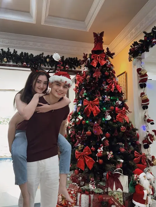 Ranty Maria dan Rayn Wijaya tampil romantis di depan pohon Natal. Kenakan busana kasual bertema Natal, Rayn Wijaya kenakan topi santa yang unik dan Ranty Maria kenakan bando bertanduk rusa [@rantymaria]