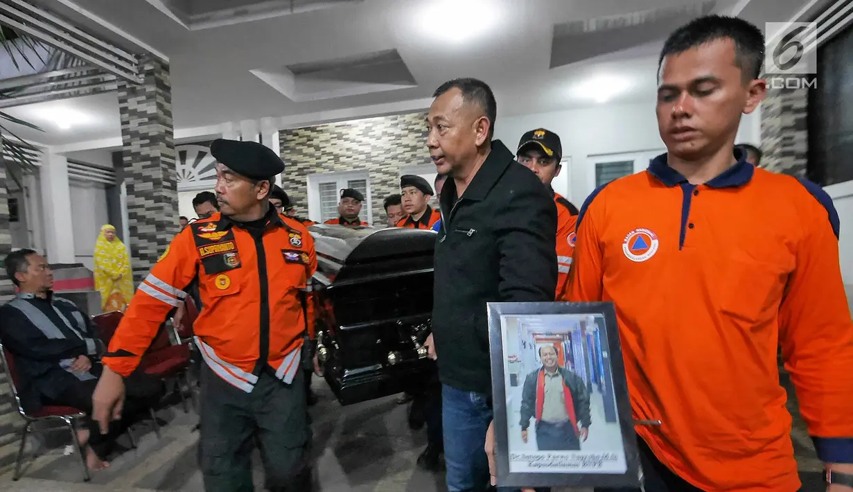 Petugas BNPB membawa jenazah Kapus Data Informasi dan Humas BNPB Sutopo Purwo Nugroho untuk diberangkatkan ke Bandara Soekarno-Hatta usai disemayamkan di rumah duka Raffles Hils, Cimanggis, Depok, Senin (7/7/2019). Sutopo akan dikebumikan di Boyolali. (Liputan6.com/Herman Zakharia)