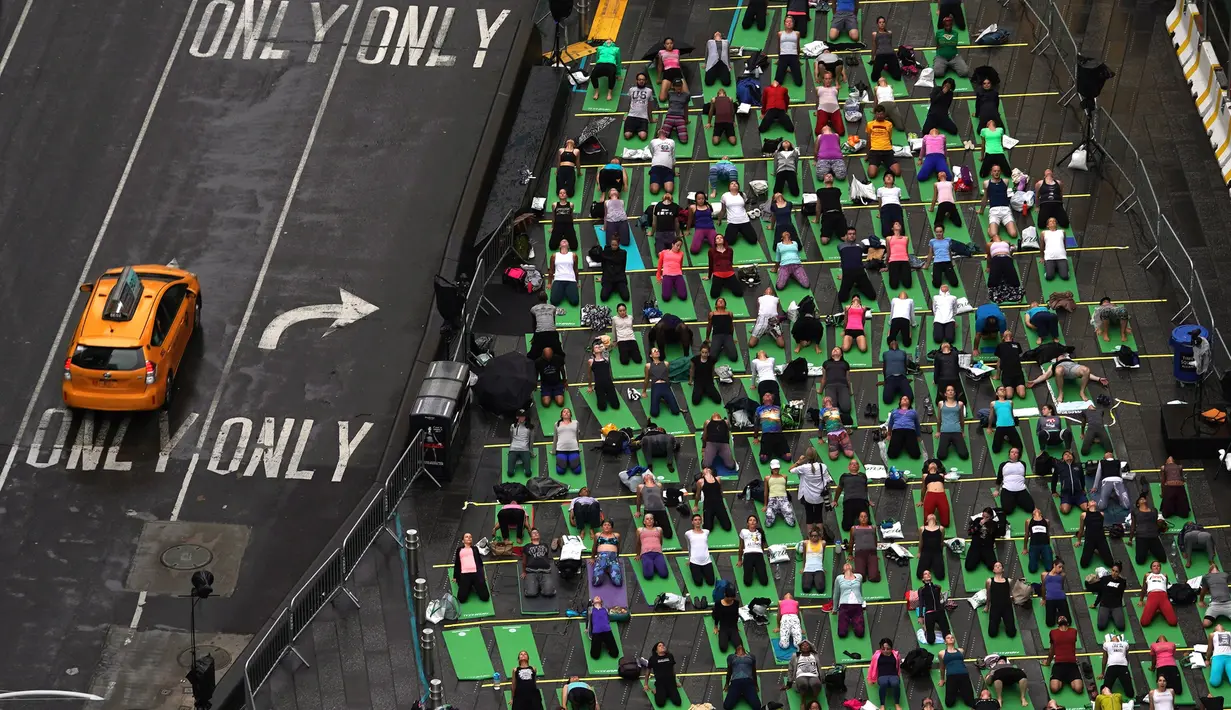 Ribuan orang berpartisipasi dalam yoga outdoor di kawasan Times Square, New York saat Summer Solstice atau hari dengan siang terpanjang di musim panas, Kamis (21/6). Acara itu menandai Hari Yoga Internasional yang jatuh pada 21 Juni (TIMOTHY A. CLARY/AFP)