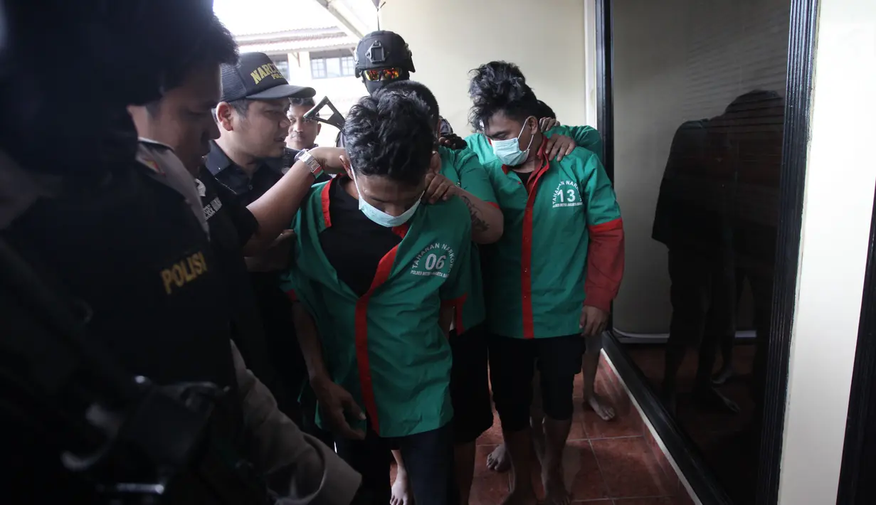 Petugas mengawal tersangka saat menggelar rilis pengungkapan 1,3 ton ganja di Polres Jakarta Barat, Kamis (4/1). (Liputan6.com/Arya Manggala)