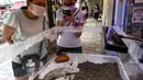 Orang-orang melihat tampilan formicarium yang menampung semut di dalam toko hewan peliharaan "Just Ants" di Singapura pada 23 September 2020. Pengusaha bernama John Ye membuka toko pertama di Singapura yang mengkhususkan diri menjual peternakan semut sebagai hewan peliharaan. (Roslan RAHMAN/AFP)