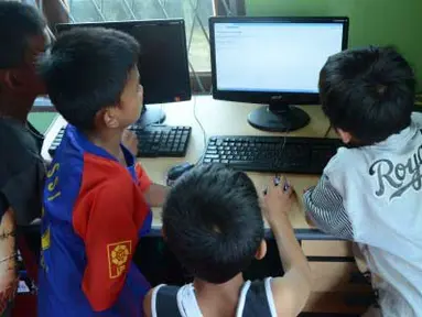 Sejumlah anak mengakses internet dari komputer yang disediakan pemkot di kawasan pemukiman kumuh Kelurahan 3-4 Ulu Palembang, Sumatera Selatan, Kamis (5/4). Sarana tersebut disediakan merupakan bagian dari program gemar membaca dan melek internet. (Antara)