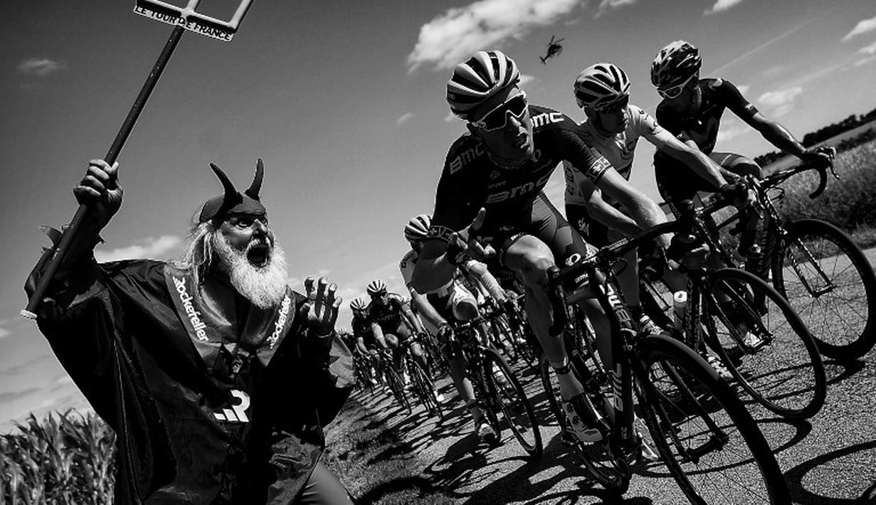 Didi Senft atau yang dikenal dengan El Diablo (kiri) menggoda Christopher Froome saat berlomba di Etape 8 Tour de France antara Rennes dan Mur-de-Bretagne, Prancis. (11/7/2015). (AFP Photo/Lionel Bonaventure) 
