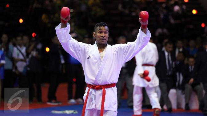 Karateka Jawa Timur, Umar Syarief mengangkat tangan usai menumbangkan Caesar George (Jakarta) di kelas Kumite Individu Putra +84 kg senior PON XIX di Sabuga, Bandung, Minggu (18/9). Umar menang telak 9-1 atas Caesar. (Liputan6.com/Helmi Fithriansyah)