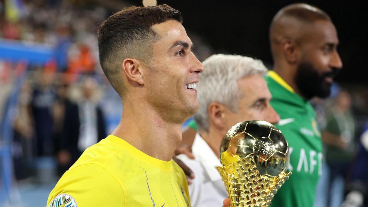 Ekspresi Cristiano Ronaldo yang tersenyum semringah sambil memegang trofi Liga Champions Arab 2023 setelah menjadi pahlawan kemenangan timnya Al Nassr yang sukses meraih juara dalam ajang kejuaraan tersebut.
