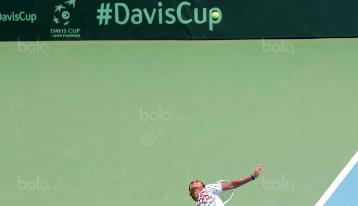 Petenis Indonesia, Althaf Dhaifullah melakukan servis saat melawan petenis Fiipina Davis 2018 grup dua Asia/Oceania di Senayan, Jakarta, Sabtu (3/2/2018). Althaf kalah 3-6, 2-6. (Bola.com/Nick Hanoatubun)