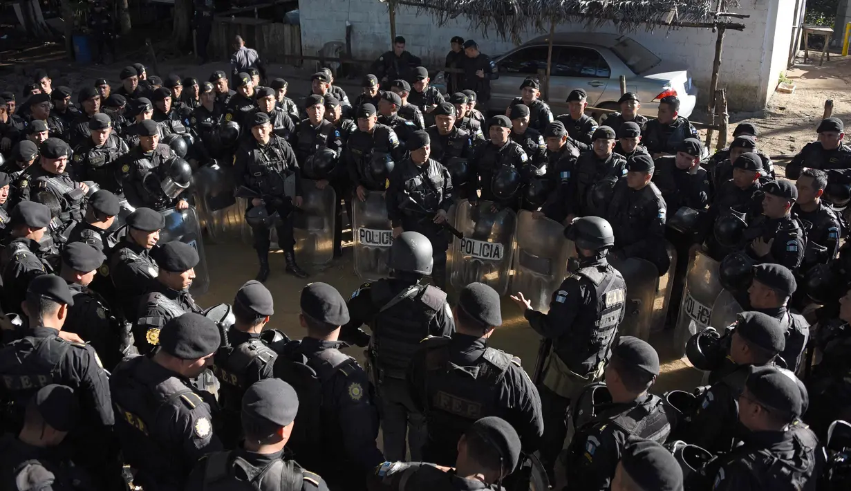 Puluhan polisi anti huru hara dikerahkan untuk mengendalikan situasi di sebuah penjara dengan keamanan maksimum di Guatemala, Senin (30/11). Sedikitnya 16 tahanan tewas dalam perkelahian antarnapi di penjara tersebut. (AFP Photo/JOHAN ORDONEZ)