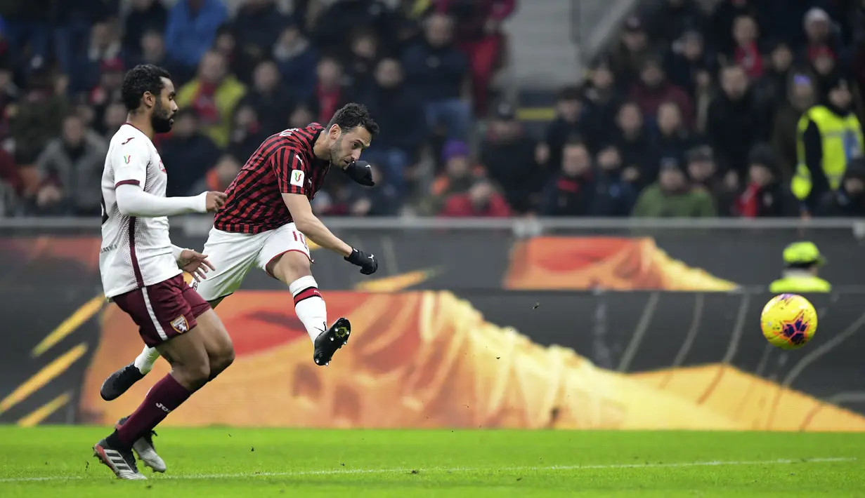 Gelandang AC Milan, Hakan Calhanoglu menembak bola saat mencetak gol ke gawang Torino pada pertandingan Liga Serie A Italia di stadion san Siro di Milan pada 28 Januari 2020. Kepastian kepindahan Calhanoglu ke Inter diumumkan langsung oleh klub, Selasa (22/6/2021) malam WIB. (AFP/Miguel Medina)