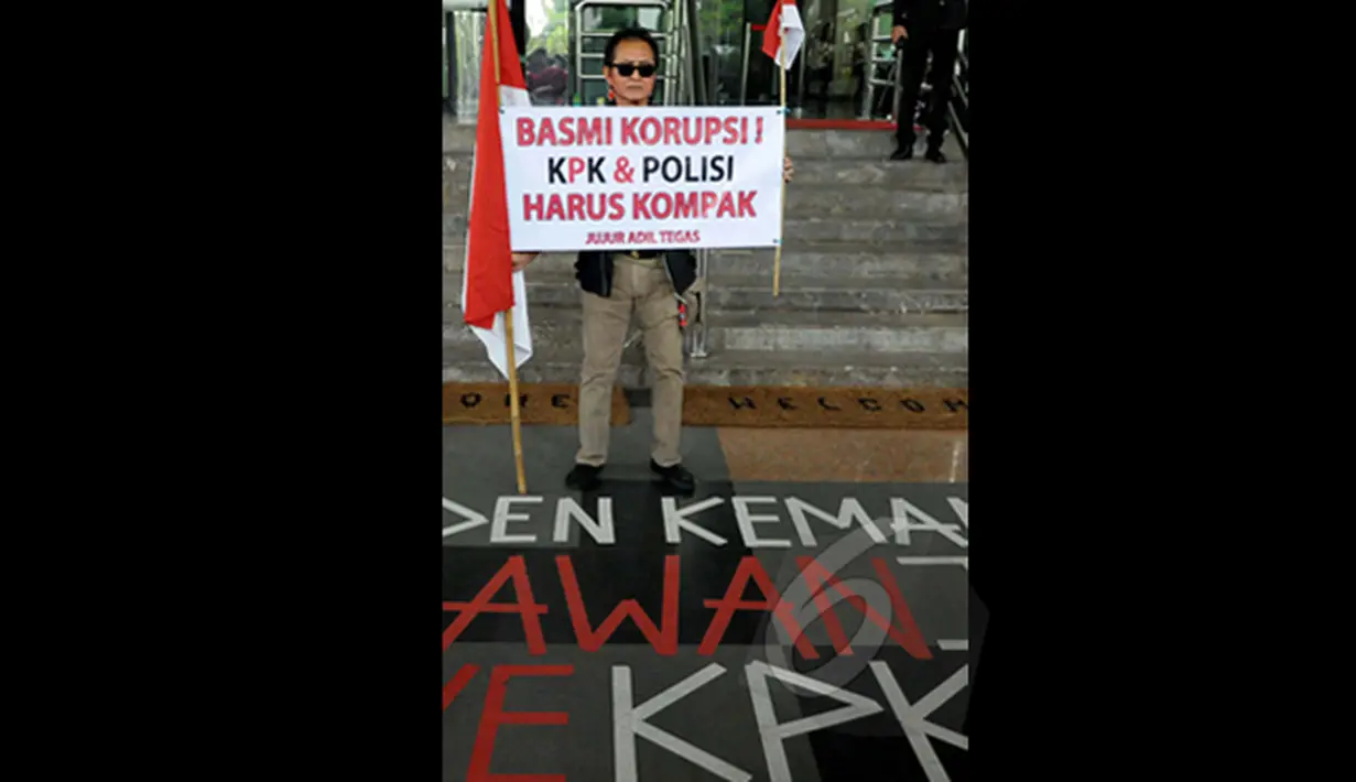 Pong Harjatmo, menggelar unjuk rasa seorang diri di Komisi Pemberantasan Korupsi (KPK), Jakarta, Rabu (28/1/2015). Pong Harjatmo menyerukan agar KPK - Polri kompak untuk memberantas korupsi yang merugikan rakyat Indonesia. (Liputan6.com/Andrian M Tunay)