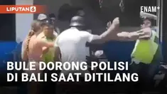Aksi meresahkan oknum bule di Bali kembali terjadi. Kamera warga merekam pasangan bule bermotor ditilang polisi. Bule pria tiba-tiba mendorong polisi yang mencoba menertibkan.