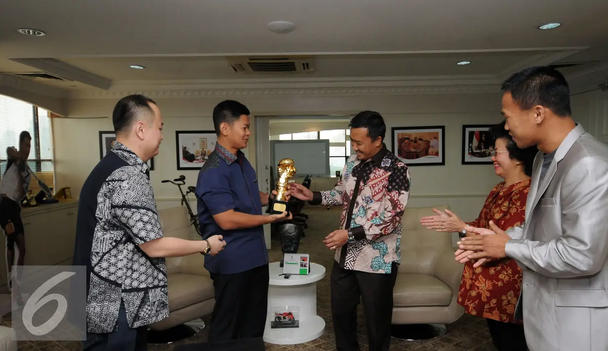 Raja Sapta Oktohari (kedua kiri) menyerahkan sarung tinju emas kepada Menpora Imam Nahrawi di Jakarta, Selasa (14/6/2016). Raja Sapta menemani Daud Yordan menemui Menpora usai merebut sabuk WBA Lightweight International. (Liputan6.com/Helmi Fithriansyah)