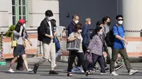 Orang-orang yang berjalan di luar sebuah stasiun di Seoul, Korea Selatan, Jumat (24/9/2021). Korea Selatan telah melaporkan lonjakan harian terbesar virus corona sejak dimulainya pandemi. (AP Photo/Lee Jin-man)