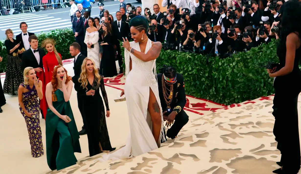 Rapper 2 Chainz berlutut saat sang kekasih, Kesha Ward memperlihatkan cincin pada Met Gala 2018 di Metropolitan Museum of Art, New York, Senin (7/5). Dalam acara Met Gala, Chainz melamar sang kekasih yang telah memberikannya dua putri. (AP/John Carucci)