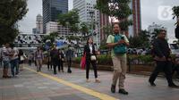Pekerja berjalan kaki saat jam pulang di kawasan Sudirman, Jakarta, Jumat (7/2/2020). BPJS Ketenagakerjaan yang kini bernama BP Jamsostek menargetkan sekitar 23,5 juta tenaga kerja baru masuk dalam daftar kepesertaan pada 2020. (Liputan6.com/Angga Yuniar)