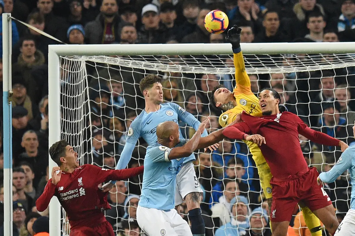 Kiper Manchester City, Ederson, menepis bola saat melawan Liverpool pada laga Premier League di Stadion Etihad, Manchester, Kamis (4/1). City menang 2-1 atas Liverpool. (AFP/Oli Scarff)