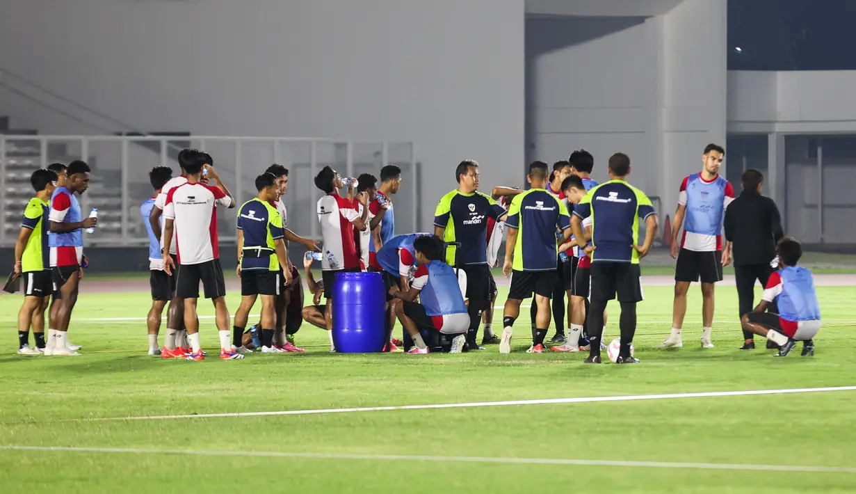 Para pemain sedang beristirahat minum usai melakukan latihan Timnas Indonesia U-20 di Stadion Madya, Jakarta Pusat, pada Minggu (22/9/2024) malam WIB. (Bola.com/Abdul Aziz)