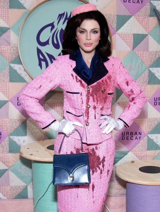 Julian Fox mengenakan setelan rok merah muda berlumuran darah, dipadukan dengan sarung tangan putih dan topi kotak pil yang serasi — sebuah replika mencolok dari pakaian yang dikenakan mantan Ibu Negara pada tanggal 22 November 1963, ketika suaminya tewas tertembak saat berkendara dalam iring-iringan mobil di Dallas, Texas. [@thisisjulianfox]