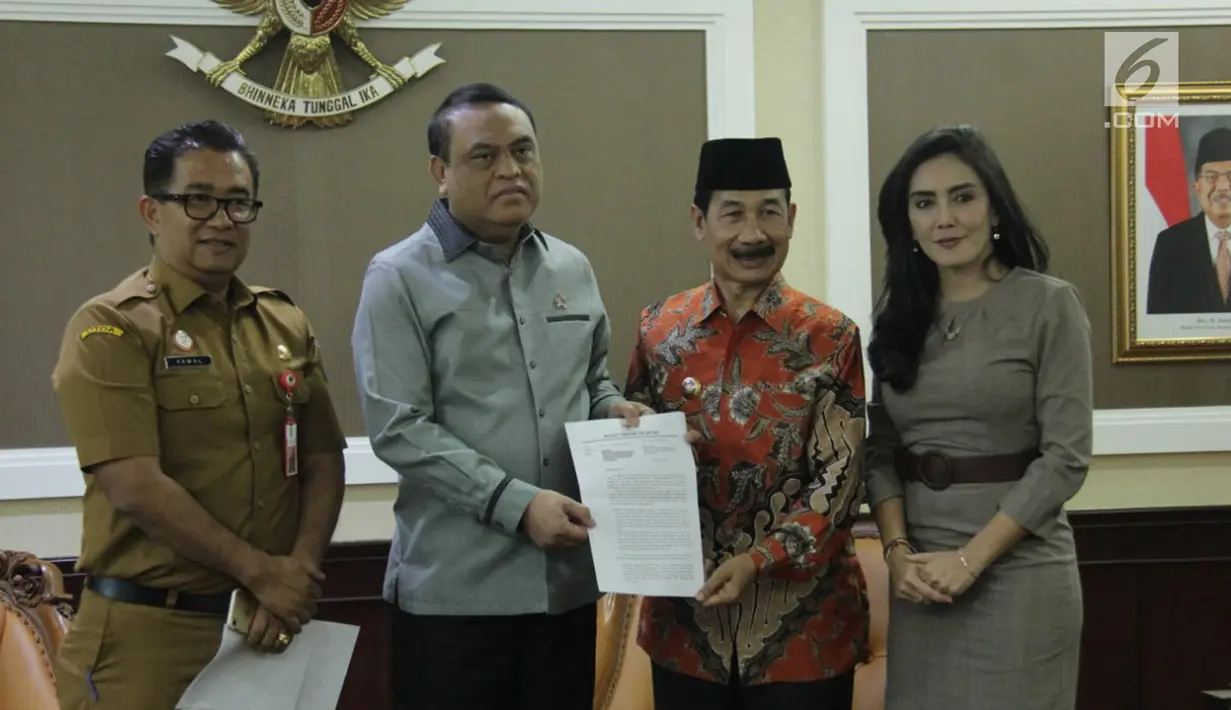Menpan RB Syafruddin (kedua kiri) dan Bupati Kabupaten Solok Selatan Muzni Zakaria (kedua kanan) menunjukkan berkas CPNS dokter gigi Romi Syofpa Ismael di kantor Kemenpan RB, Jakarta, Senin (5/8/2019). (Liputan6.com/Angga Yuniar)
