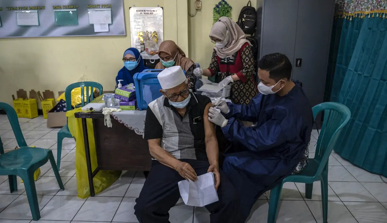 Seorang pria menerima dosis vaksin booster COVID-19 Pfizer di Surabaya, Jawa Timur, Kamis (13/1/2022). (JUNI KRISWANTO/AFP)