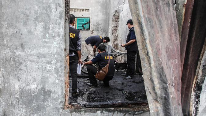 Tim penyelidik bekerja di lokasi kebakaran pabrik korek gas di Binjai, Langkat, Sumatera Utara, (21/6/2019). Polda Sumut juga meminta pemeriksaan secara laporan forensik melalui Tim Disaster Victim Identification (DVI) untuk mengetahui perorangan dari korban. (Ivan Damanik/AFP)