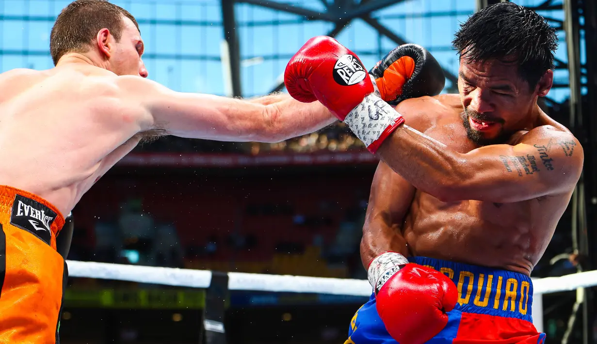 Petinju Filipina, Manny Pacquiao, menangkis pukulan dari Jeff Horn (Australia) pada perebutan sabuk juara kelas welter versi WBO di Stadion Suncorp, Brisbane, Minggu (2/7). Horn yang tak diunggulkan justru mampu mengalahkan Pacquiao (PATRICK HAMILTON/AFP)
