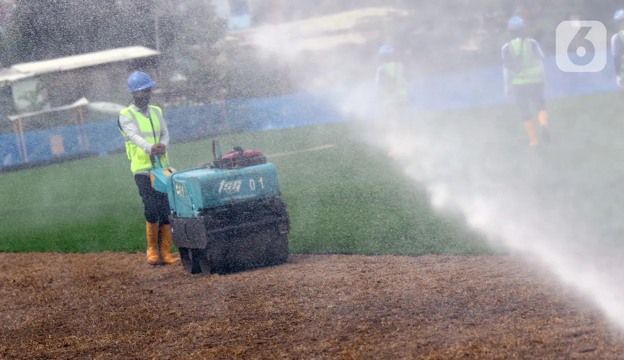 Pekerja melakukan proses perataan tanah untuk pemasangan rumput hybrid di area lapangan latih Jakarta International Stadium, Jumat (23/10/2020). Sebanyak dua lapangan latih JIS mulai dilakukan pemasangan rumput hybrid dan ditarget selesai pada Desember 2020. (Liputan6.com/Helmi Fithriansyah)