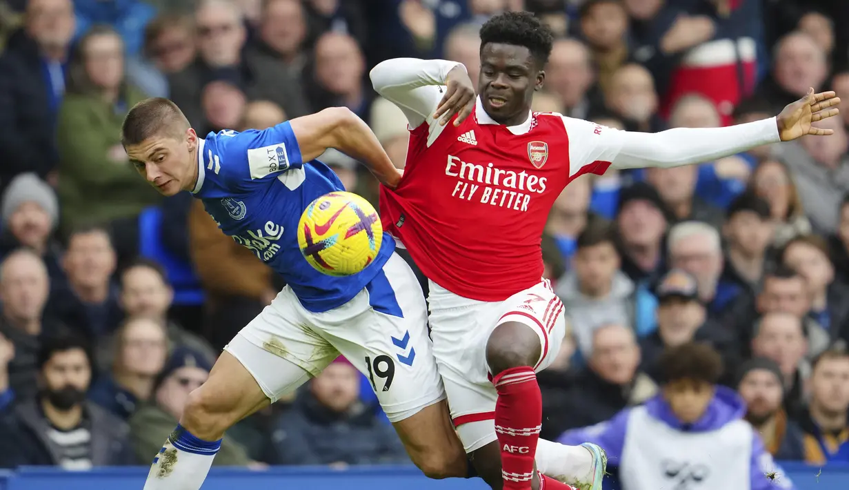 Bek kiri Everton, Vitaliy Mykolenko (kiri) berusaha menghentikan laju sayap kanan Arsenal, Bukayo Saka dalam laga pekan ke-22 Liga Inggris 2022/2023 di Goodison Park, Liverpool, Sabtu (4/2/2023) malam WIB. (AP Photo/Jon Super)