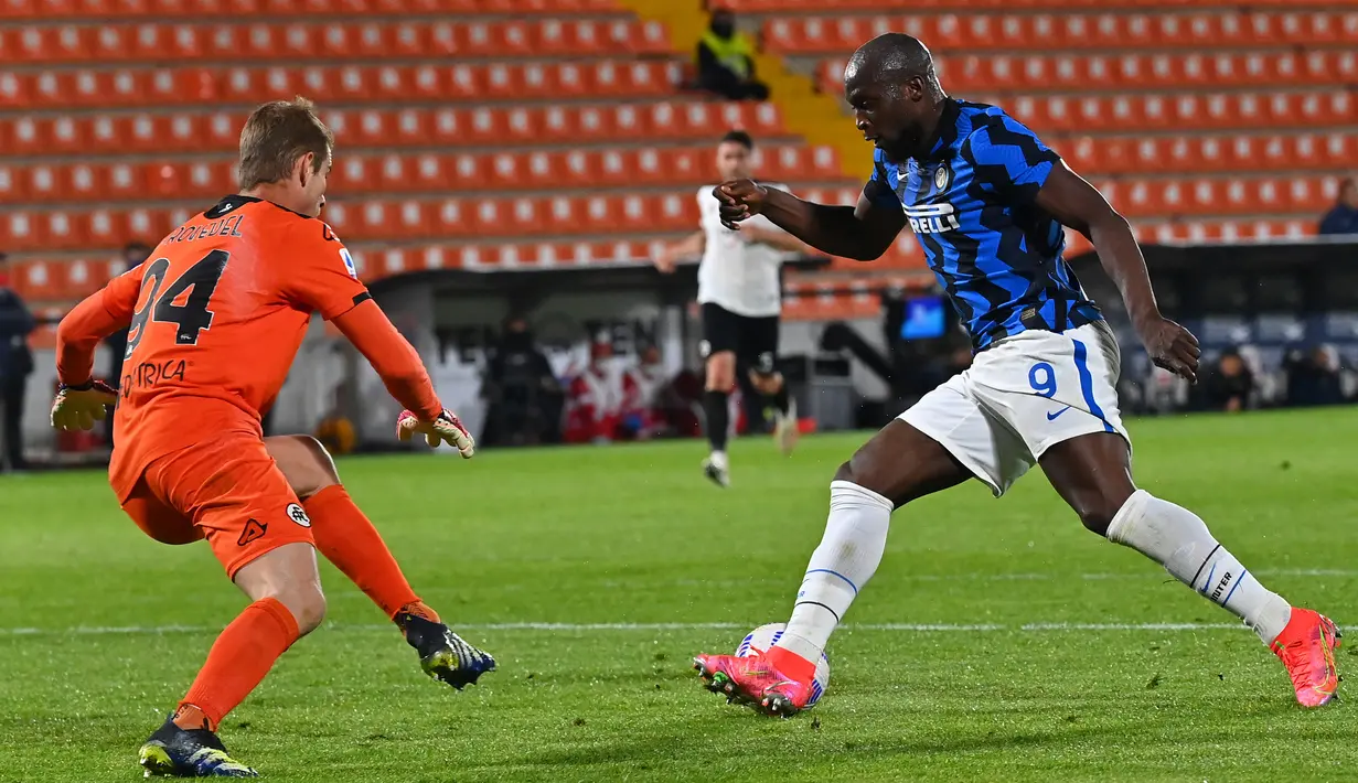 Pemain Inter Milan Romelu Lukaku (kanan) duel dengan kiper Spezia Ivan Provedel pada pertandingan Serie A Liga Italia di Stadion Alberto-Picco, La Spezia, Italia, Rabu (21/4/2021). Pertandingan berakhir dengan skor 1-1. (ANDREAS SOLARO/AFP)