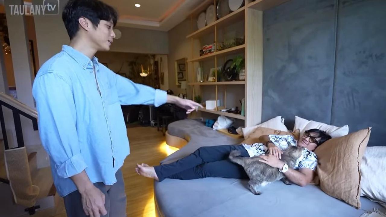 Pradikta Wicaksono atau yang lebih dikenal sebagai Dikta, mantan personel Yovie and Nuno memperlihatkan ruang tamunya ke Andre Taulany. (Dok: Youtube Andre Taulany)