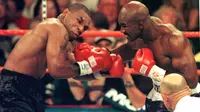 Mike Tyson dan Evander Holyfield kembali berduel di MGM Grand Garden Arena, Las Vegas pada 28 Juni 1997. Akan tetapi, laga akbar ini harus dihentikan pada ronde ketiga, karena Tyson menggigit kuping Holyfield. (AFP/JOHN GURZINSKI)